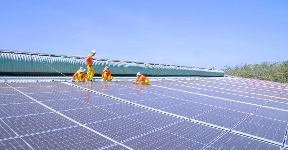 Kỹ thuật viên kiểm tra hệ thống điện mặt trời bám tải trên mái công trình tại Hà Nội.